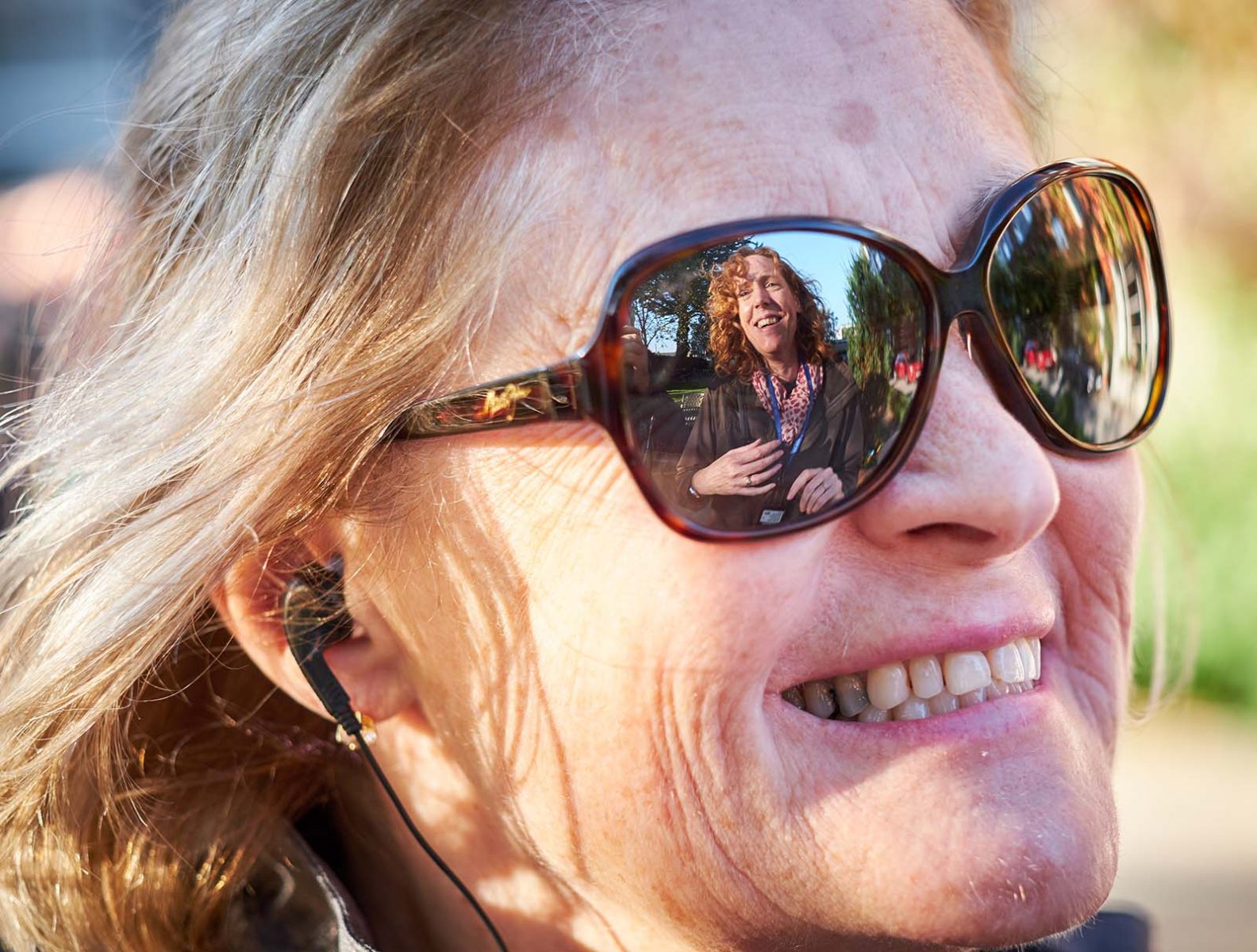 Close up of tour member showing Jane reflected in her sunglasses