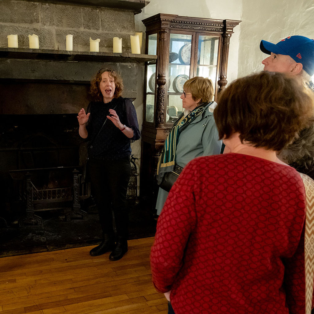 Jane at fireplace with dark history tour group