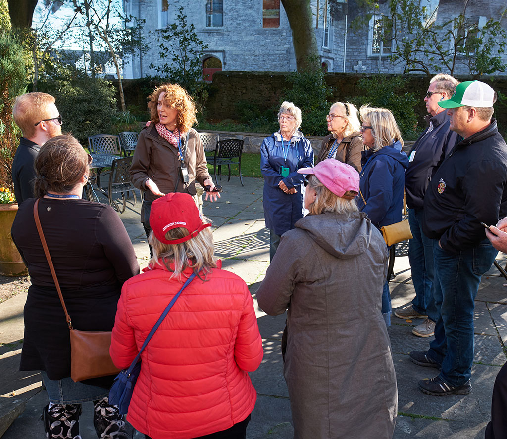 Jane with tour group outside The Old Ground Hotel - wide shot
